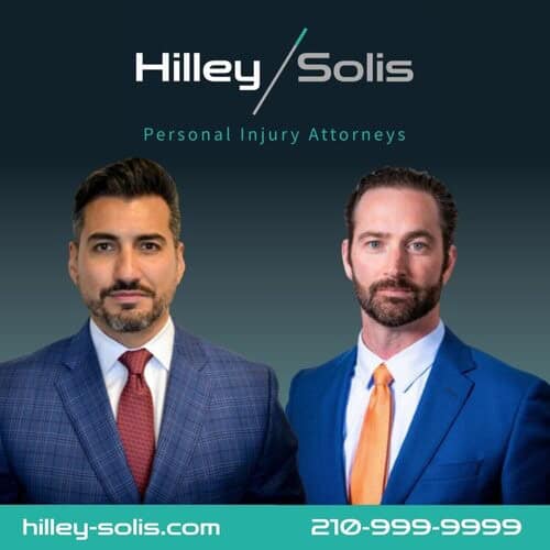 Two men in suits posing in a promotional image for Hilley/Solis Personal Injury Attorneys, with contact details at the bottom.
